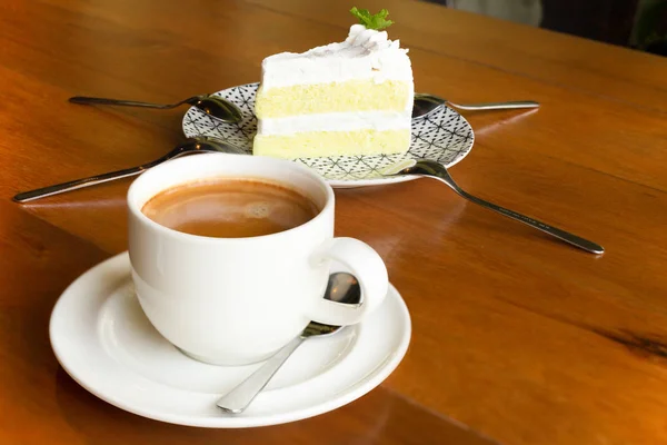 Kopp kaffe med tårtbit på träbord i Café. — Stockfoto