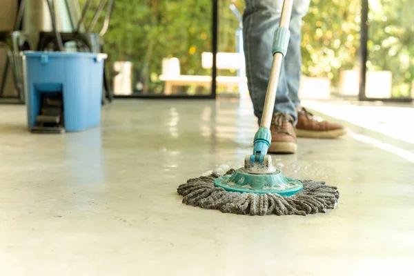 Hombre trabajador con fregona y cubo piso de limpieza en la cafetería . — Foto de Stock