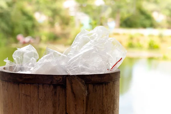 Concetto di evacuazione Rifiuti di sacchetti di plastica nel cestino di legno per il riciclaggio . — Foto Stock