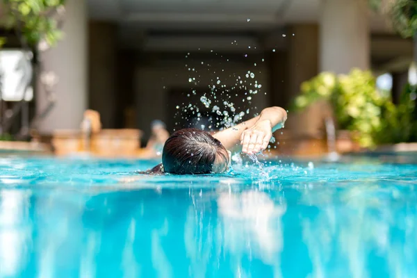 Unidentified woman doing front crawl swimming in swimming pool on vacation. — Stock Photo, Image