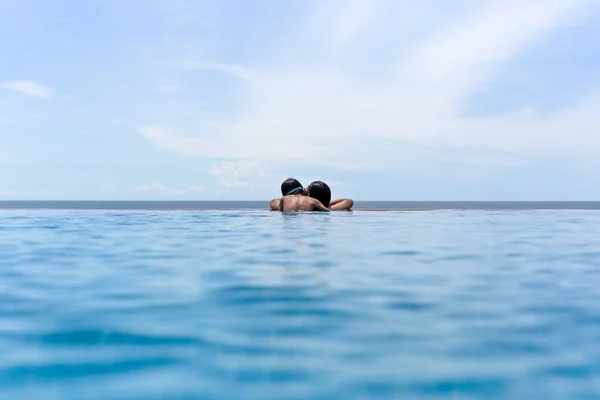 Madre e hijo pequeño se relajan en la piscina mirando sobre el océano en las vacaciones de verano . —  Fotos de Stock