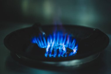 Yemek pişirmek için gaz sobası üzerinde mavi gaz alevleri.
