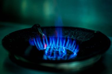 Yemek pişirmek için gaz sobası üzerinde mavi gaz alevleri.