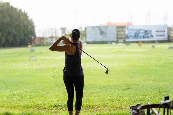 Mujer asiática practicando su swing de golf en el campo de golf . — Foto de Stock