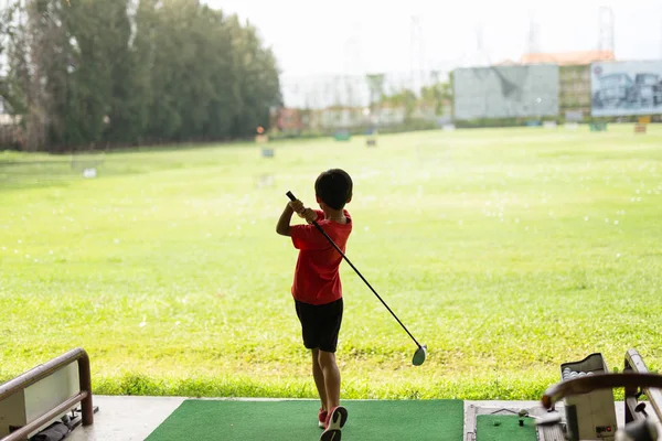 Genç asyalı çocuk golf sürüş aralığında onun golf salıncak pratik. — Stok fotoğraf