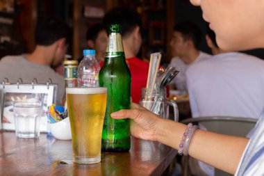 Kadın el reataurant masada bira şişesi tutan.