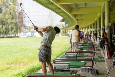 Golf sürüş sahasında golf salıncağı yapan adam.