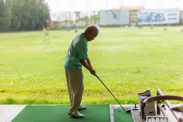 Bangkok Tailândia - 27 Jul 2019 Exercício de homem sênior praticando seu balanço de golfe na gama de condução de golfe . — Fotografia de Stock