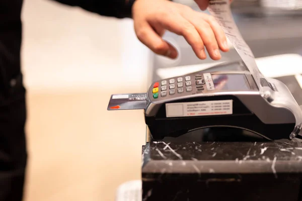 Cajero masculino mano poner tarjeta de crédito en caja registradora para el pago del cliente . — Foto de Stock