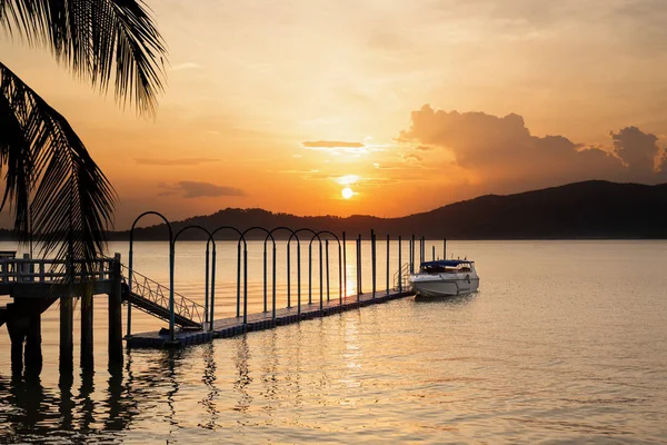 Barco de velocidad en el muelle flotante con hermosa puesta de sol en el fondo . — Foto de Stock