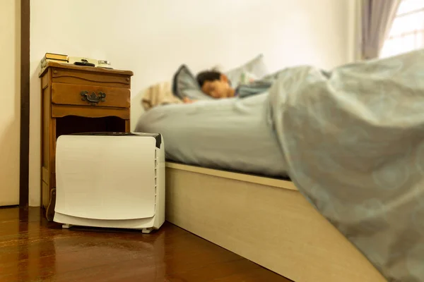 Air purifier in the bed room with young boy sleeping in bed. — Stock Photo, Image