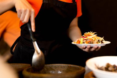 Kadın restoranda yengeç ile Tayland baharatlı papaya salatası yapma.