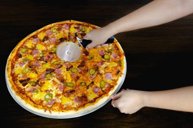 El yapımı pizzayı masanda pizza makasıyla dilimlemek..