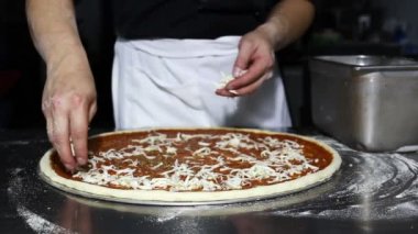Şef, Pizzeria 'da Pizzaya Hazırlık Pizzası Yaparken Izgara Peynir Koyuyor.