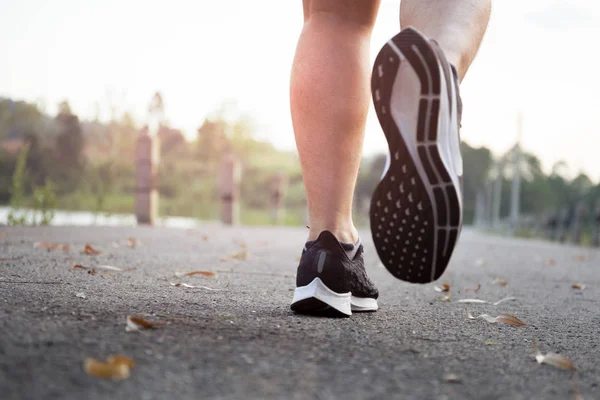 Primeros planos zapatillas Atletas piernas corriendo en la calle para maratón de verano . — Foto de Stock