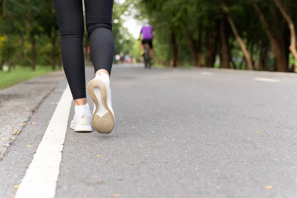 Zapatillas de deporte de los atletas de primer plano ejercicio caminando a pie por la mañana . — Foto de Stock
