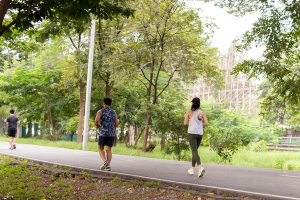 Fitness sport mujer y hombre corriendo por el sendero en el parque por la mañana . — Foto de Stock