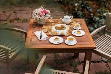 Öğleden sonra çay bası yanmış cheesecake ve çay fincanı ahşap masada.