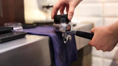 Barista taze kahve yapmak için kahve çekirdeğine topraklanmış kahve damgaladı..