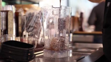Kahveyi buzla karıştırıp buzlu kahve yapan barista..