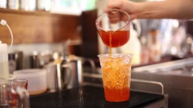Barista bardağa çay doldurur Yaz buzlu çayı yapar.