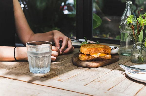 Wanita Memiliki Sandwich Telur Dengan Keju Dan Segelas Air Tawar — Stok Foto