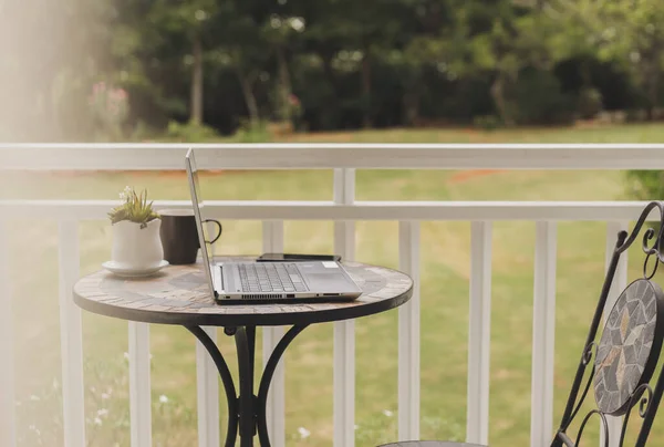 Laptop Und Kaffee Auf Dem Tisch Balkon Garten Grüne Bäume — Stockfoto