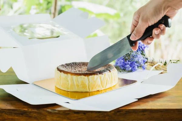 Frau Schneidet Baskenmütze Mit Messer Auf Holztisch — Stockfoto
