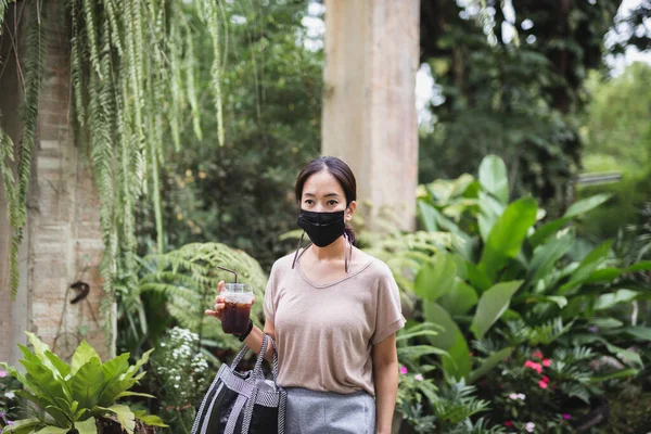 Woman Protective Mask Hand Hold Iced Coffee Walk Greenery Park — Stock Photo, Image