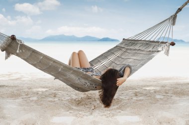 Yaz tatilinde tropik bir plajda hamakta bir kadın