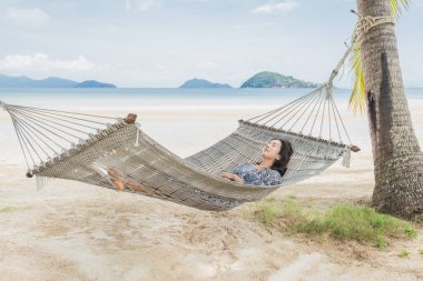 Sahilde hamakta uyuyan güzel bir kadın.