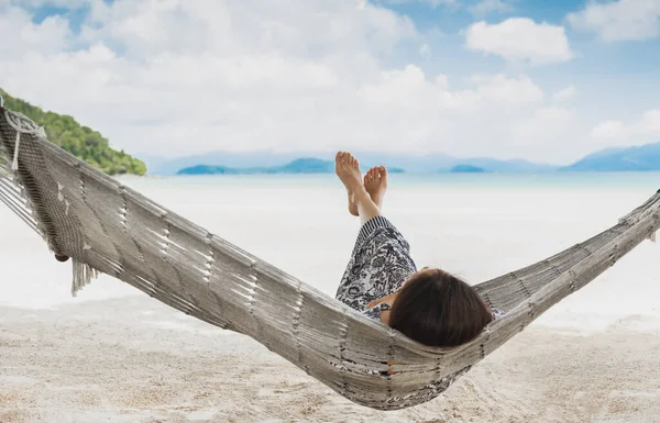 Woman relaxing in the hammock with her feet up in tropical beach on summer vacation