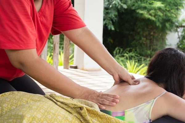 Kadın tatilde kaplıcada sırt masajı yaptırıyor.