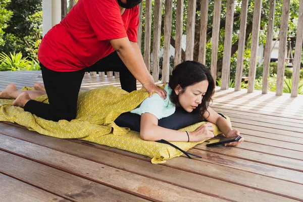 Kadının cep telefonu kullanırken Tayland masajı yaptırması yeni normal bir kavram.