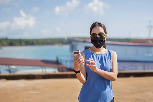 Kobieta Masce Ochronnej Okularach Przeciwsłonecznych Pomocą Smartfona Wakacjach — Zdjęcie stockowe