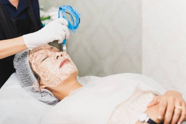 Profesyonel klinikte canlandırıcı yüz tedavisi gören bir kadın.
