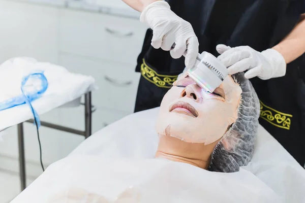 Woman getting laser and ultrasound face treatment in medical spa