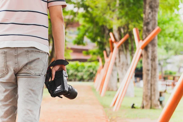 Visão Traseira Turista Segurando Câmera Digital Sua Mão Andando Parque — Fotografia de Stock