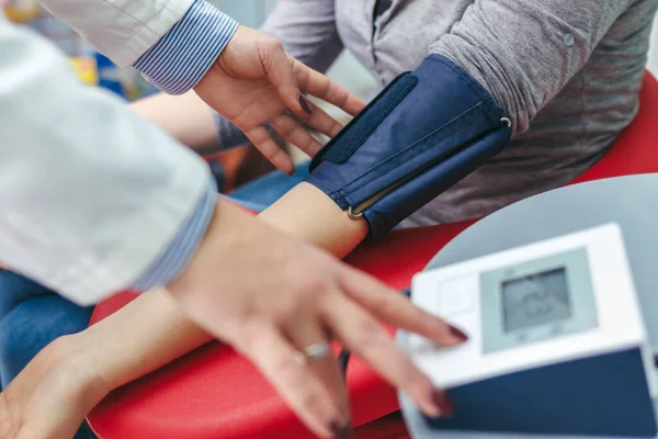 Doctor checking blood pressure with digital monitor