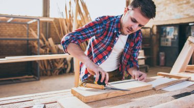 Marangoz çalışıyor, ahşap yapıyor ve onunla çalışıyor.