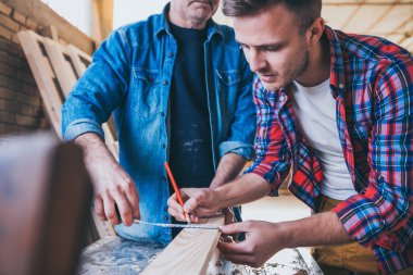 Marangozlar iş başında, ahşapla çalışıyor ve inşa ediyorlar.