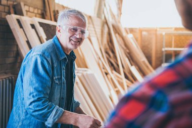 Marangozlar iş başında, ahşapla çalışıyor ve inşa ediyorlar.