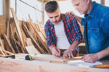 Marangoz ahşabı inşa ediyor ve ölçüyor. Takım olarak çalışıyoruz.