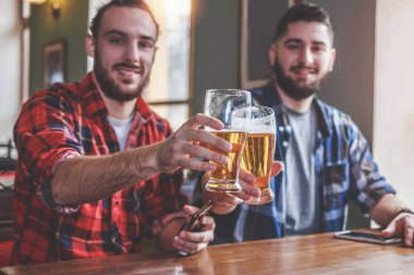 Arkadaşlar barda ya da barda bira içip kadeh tokuşturuyor.