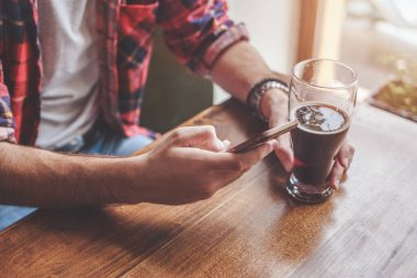 Bira içmek ve barda akıllı telefon kullanmak. Kapat.