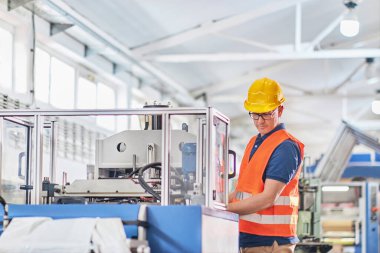 Fabrikadaki üretim hattı. Endüstriyel tesis veya kamu hizmetlerindeki ekipmanları kontrol eden veya ayarlayan teknisyen veya mühendis