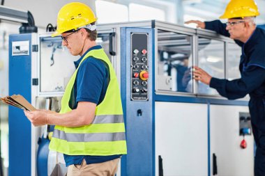 Mühendisler plastik poşet üretiminde çalışıyorlar. Yazdırma makinesi