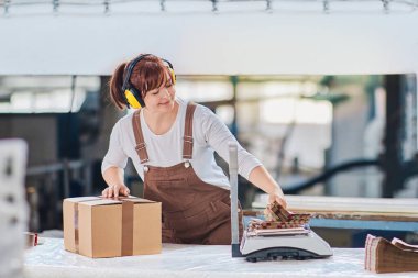 Fabrikada çalışan bir kadın, depoda ambalaj işlemi