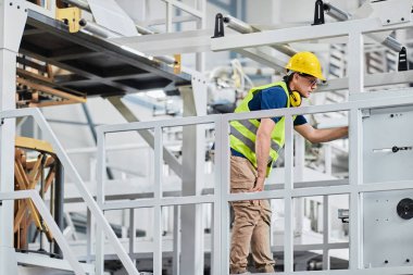 Foreman yöneticisi veya mühendisi verilerle çalışıyor ve endüstriyel makinenin çalışmalarını kontrol ediyor