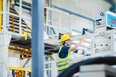 Fabrikadaki üretim hattı. Endüstriyel tesis veya kamu hizmetlerindeki ekipmanları kontrol eden veya ayarlayan teknisyen veya mühendis